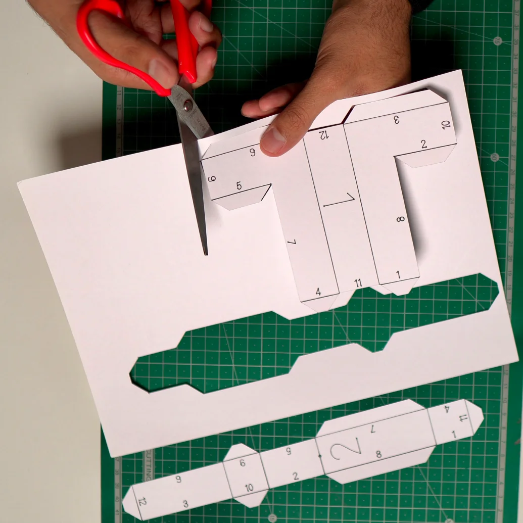 Scissors cutting the first numbered piece out of the sheet, the second piece already cut free