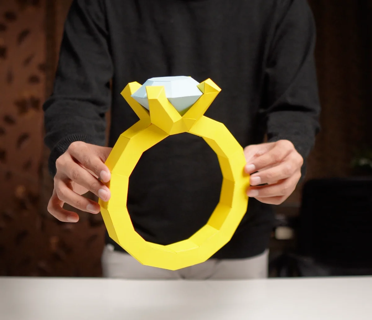 The finished paper diamond ring, held up in both hands